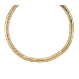 A flexible collar necklace, by Cartier, composed of a series of ridge-shaped herringbone style