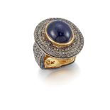 A cabochon sapphire and diamond ring, the central collet-set cabochon sapphire with pave single-