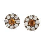 A pair of citrine and diamond cluster earrings, each designed as a claw-set citrine with circular-