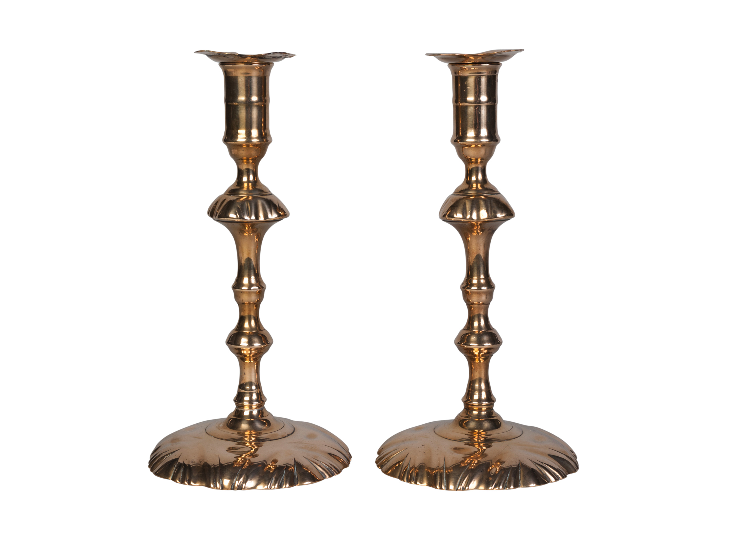 A pair of George III brass candlesticks, probably by E.Berry, late 18th century, each with shell-