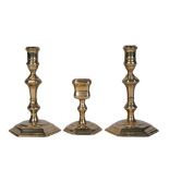 A matching set of Queen Anne brass candlesticks and snuffer stand, early 18th century, all with