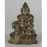 A South-East Asian silvered bronze seated deity, late 19th century, modelled seated on a shaped