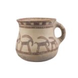 A Western Asiatic pottery handled cup, the deep bowl with rounded base and flared rim, the
