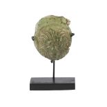 A Roman green glass token fragment in the form of a lion head, 1st-4th century AD, 4cm. high, on