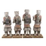 Four large Chinese grey stoneware guardian figures, Han dynasty, each modelled standing, wearing a