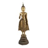 A Thai gilt copper alloy standing buddha, early 20th century, with right hand in abhaya mudra, on