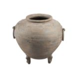 A Chinese pottery tripod jar, Han dynasty, with taotie mask and ring handles, incised to the