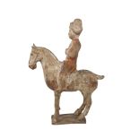 A Chinese pottery figure of a horse and rider, Tang dynasty, with traces of painted decoration to