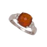 A fire opal and diamond ring, the cushion-shaped rose-cut fire opal in four claw mount to circular-