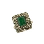 An emerald and diamond cluster ring, the single rectangular-cut emerald in claw-set mount to a