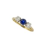 An 18ct gold, sapphire and diamond three stone ring, the circular-cut sapphire in claw-set mount
