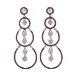 A pair or diamond and ruby drop earrings, each composed of three graduated openwork hoops each