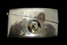 A silver card case depicting a dog