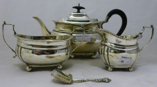 A silver three piece tea set and a caddy spoon