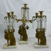 A Victorian three piece gilt metal cut glass figural garniture