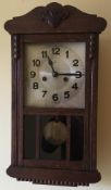 An early 20th century oak wall clock