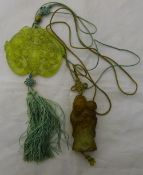 A hand carved Chinese green hardstone disc shaped pendant and a carved hardstone pendant of a sage