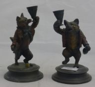 A pair of bronze fox candlesticks