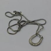 A white gold diamond set horse shoe pendant