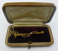 A gold bar brooch