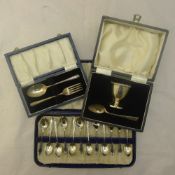Two cased silver christening sets and a cased set of silver coffee spoons