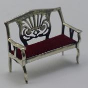 A miniature silver sofa