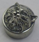 A white metal pill box with a cat formed lid