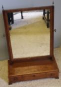 A Georgian mahogany toilet glass with three drawers and brass finials