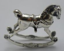 A silver miniature rocking horse