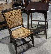 An Edwardian occasional table and caned chair