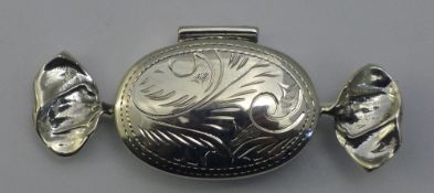 A silver pill box in the form of a sweet