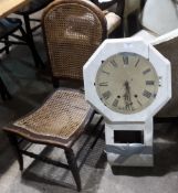 A caned nursing chair and a white painted wall clock