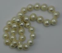 A string of white pearls with a 14 ct gold clasp