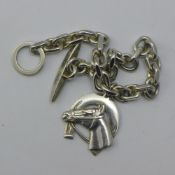 A silver bracelet set with a horse's head and horse shoe pendant