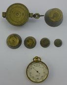 A Victorian pocket barometer and a set of bronze cup weights