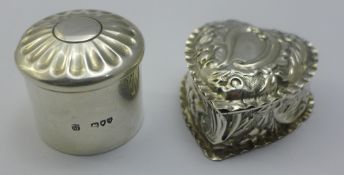 A silver heart shaped pill box and another