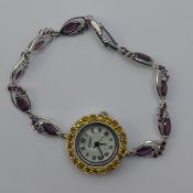 A yellow sapphire and tourmaline watch