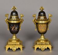 A pair of Egyptian revival ormolu mounted twin handled porcelain urns and covers Polychrome