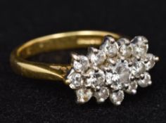 An 18 ct gold diamond cluster ring The central stone spreading to approximately 0.25 carat. 1.