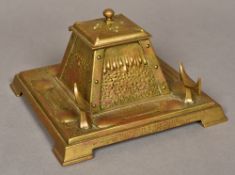 An Art Nouveau pressed brass inkwell Of hinged pyramidal form, on a square plinth base,