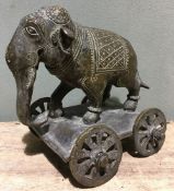 A bronze Mughal model of an elephant With incised decoration, mounted on a four-wheeled plinth base.