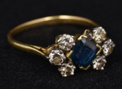 An unmarked sapphire and diamond ring The central facet cut square sapphire flanked by two rows