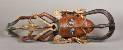 A Guro carved wood and polychrome decorated mask The slender scarified face surmounted with horns