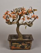 A Chinese hardstone mounted model of a bonsai tree Housed in a lacquered jardiniere. 23.5 cm wide.