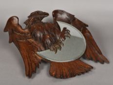 A Blackforest carved walnut wall glass Formed as an eagle holding the bevelled crescent moon mirror