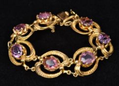 A 9 ct gold amethyst mounted bracelet Of pierced scrolling form. Approximately 16 cm long.