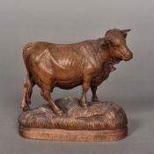 A Blackforest carved cow Modelled wearing a bell, standing on a naturalistically carved plinth base.
