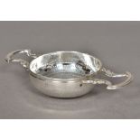 A George III silver twin handled strainer, marks indistinct Of typical pierced circular form,