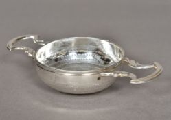 A George III silver twin handled strainer, marks indistinct Of typical pierced circular form,