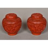 A pair of Chinese red cinnabar lacquer vases and covers Both typically worked with floral vignettes